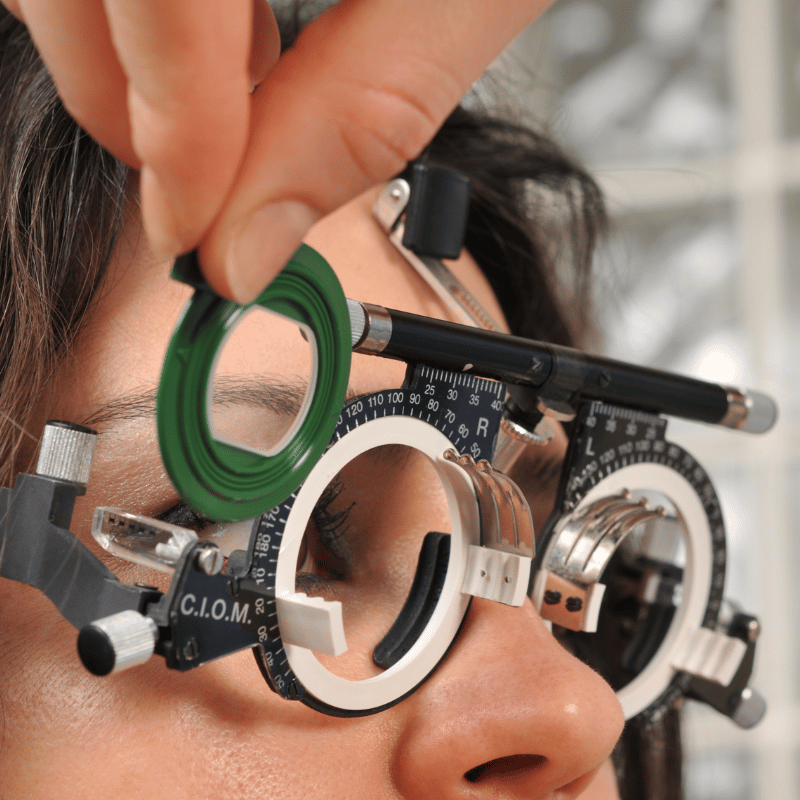 Girl getting eyes checked with manual phoropter