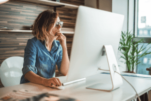Young female professional working in front of a large computer screen