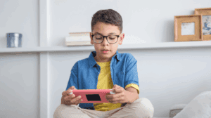 Kid wearing glasses while looking at a tablet
