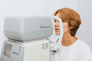 Woman sitting in front of an auto-refractor