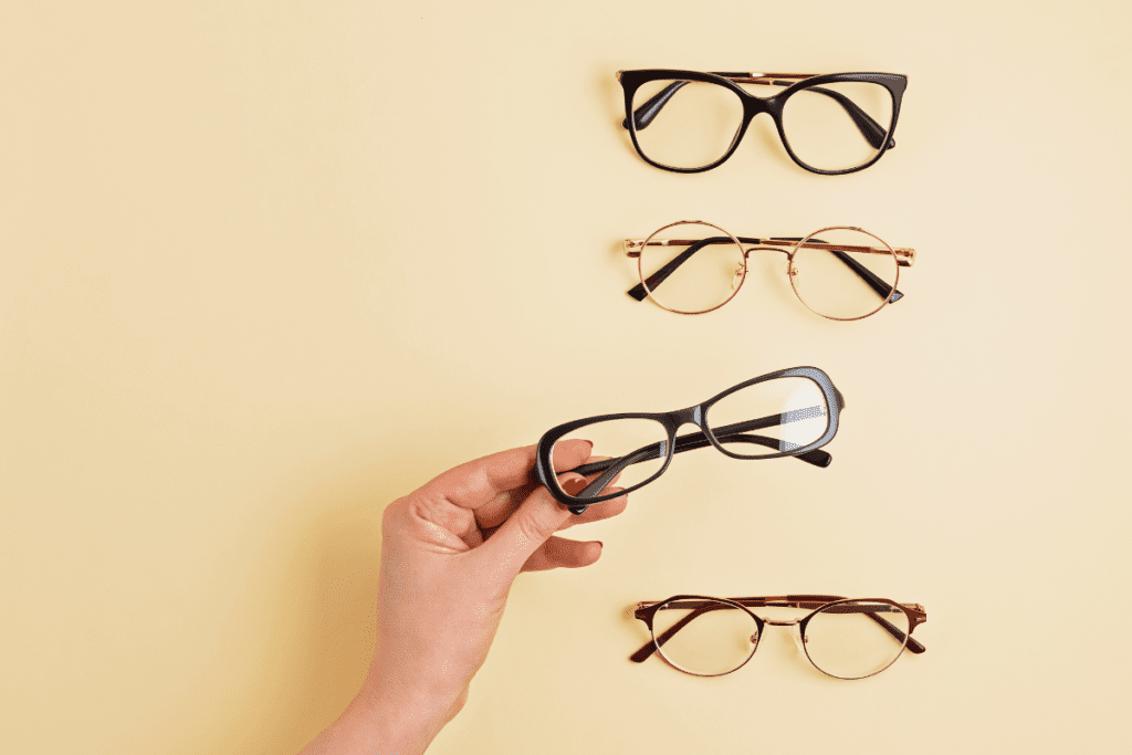 Person grabbing a pair of glasses out of a selection of 4