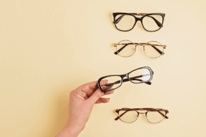 Person grabbing a pair of glasses out of a selection of 4