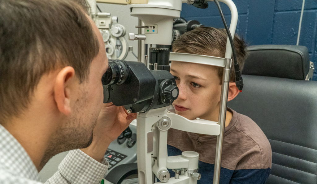Dr Ball performing an eye exam on a kid
