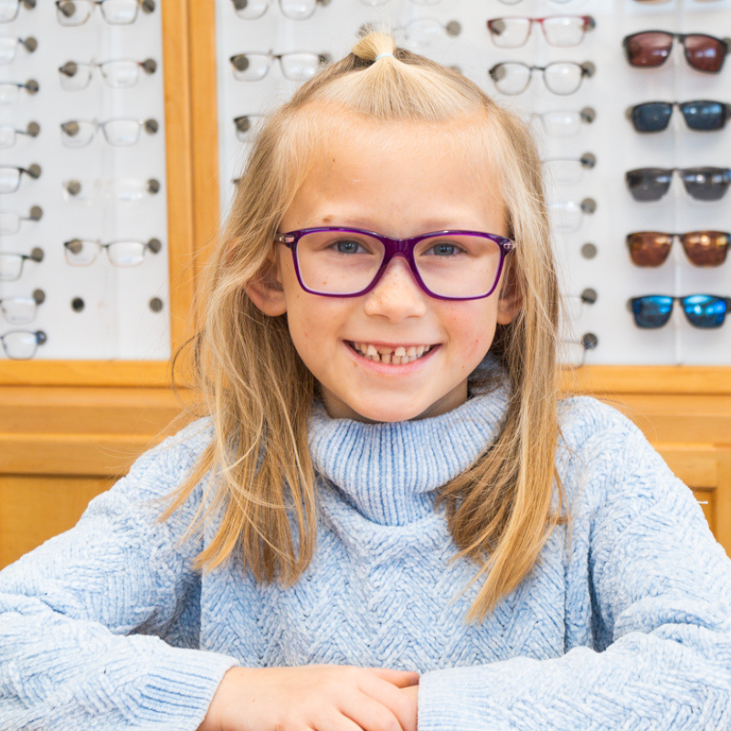 Young girl wearing glasses while sitting in an optical