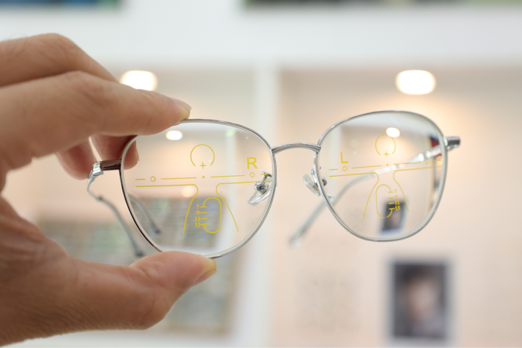 Eye doctor holding progressive lenses with markings for visual fields